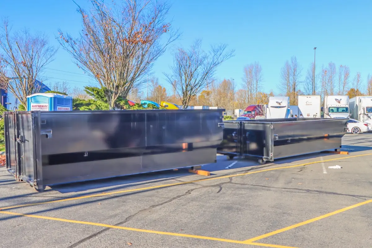 Professional dumpster rental service with roll-off container on residential driveway in Greenville